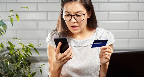 Fear and frustration - woman with a credit card and phone