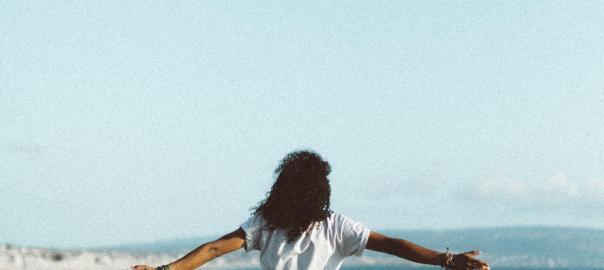 Person leaning against a rail in front of a lake